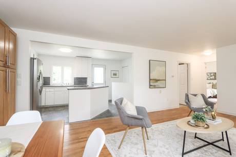 Dining area looking into the living room with white walls and daylight