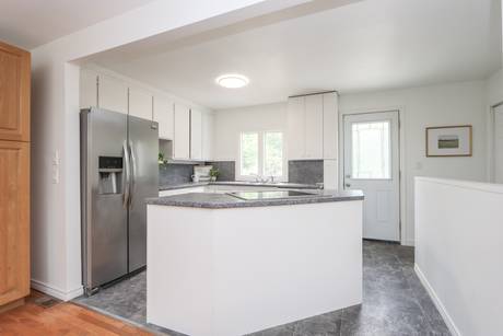 Kitchen with white cabinets, stainless appliances and a peninsula counter
