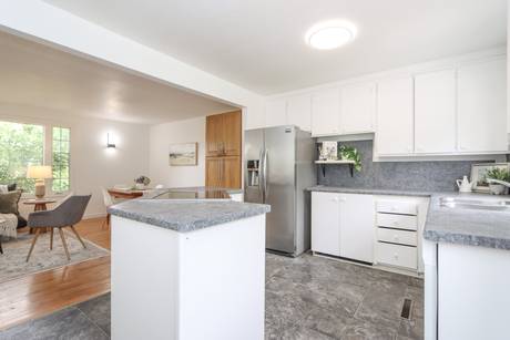 Kitchen refrigerator and peninsula seen from the living side