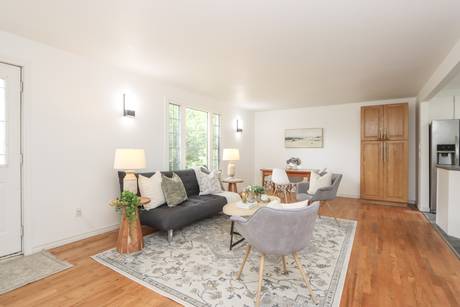 Living area showing the front door, seating and dining table in daylight