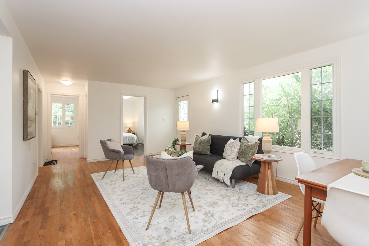 Open-plan living and kitchen space with white walls and wood floors